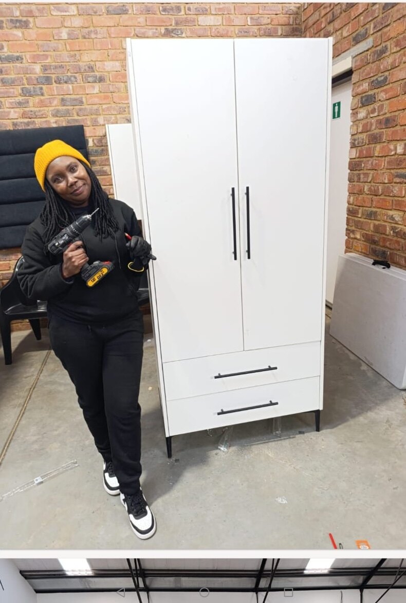 Maker standing beside a custom wardrobe